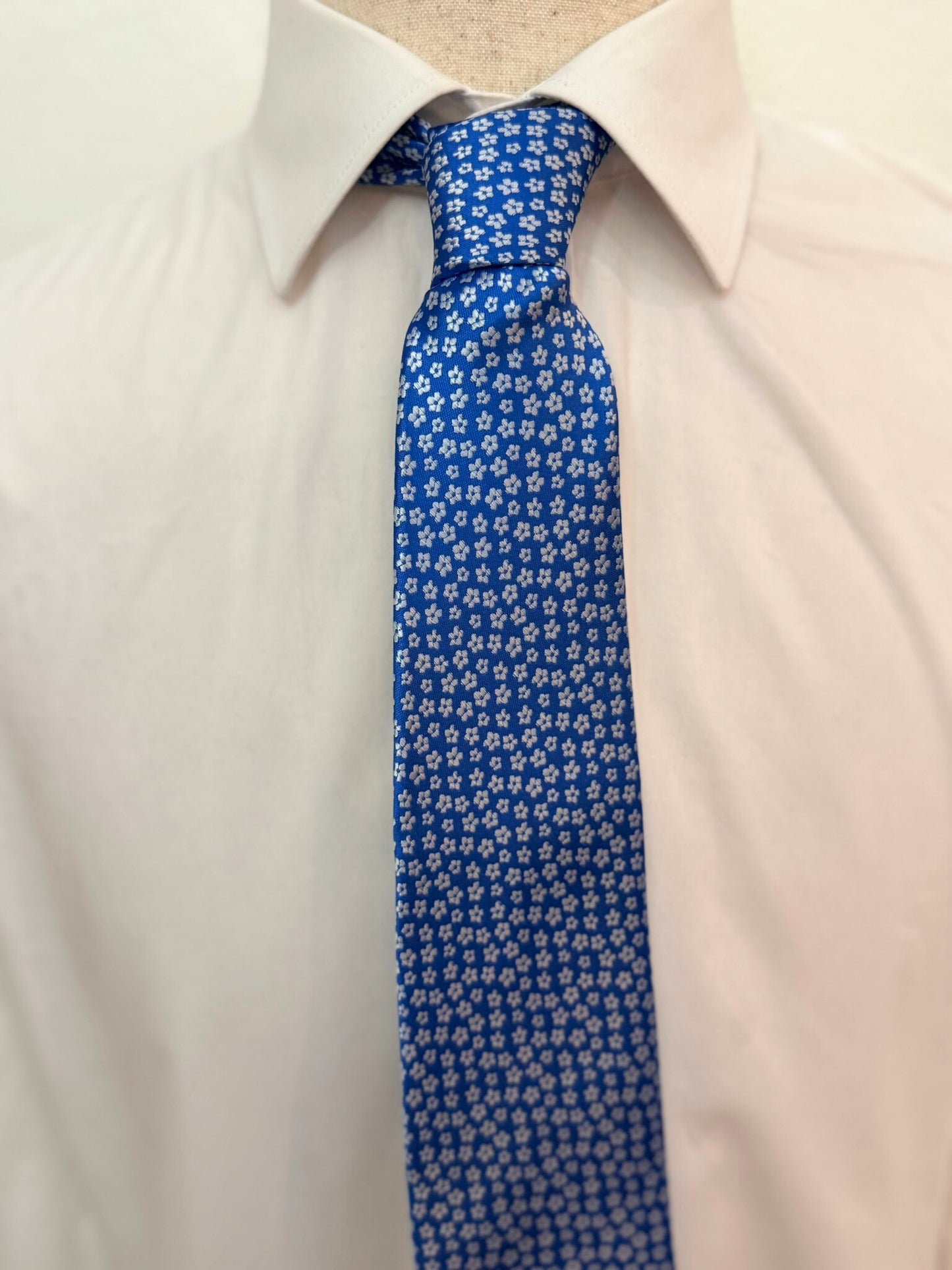 Flor gris sobre corbata azul